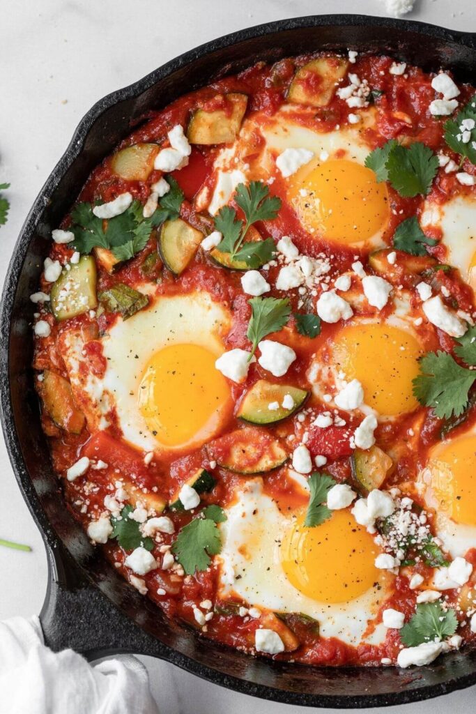 Super delicious healthy shakshuka with perfectly sunny side up eggs and crumbled feta