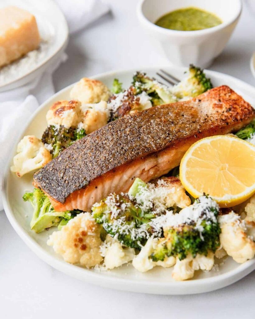 Crispy Salmon with parmesan roasted cauliflower and broccoli. The perfect healthy salmon bowl dinner or lunch. Also ideal for families and meal prep! Recipe by Healthful Blondie.