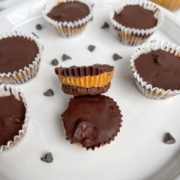 Healthy no-bake layered peanut butter cups that are easy, rich, and decadent. Close up shot of homemade peanut butter cups. Made with only 7 simple ingredients, these chocolate peanut butter bites are a delicious dessert, snack, and treat! Made vegan, grain free, and gluten free. No oven required! #nobakedessert #peanutbuttercups #healthydessert #vegandessert #glutenfreedessert