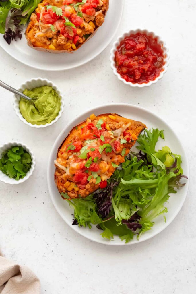 Best ever stuffed sweet potatoes with a taco filling. This easy, healthy, and delicious dinner is so easy to make!! Top your sweet potato tacos with salsa, avocado, guacamole, and cheese!