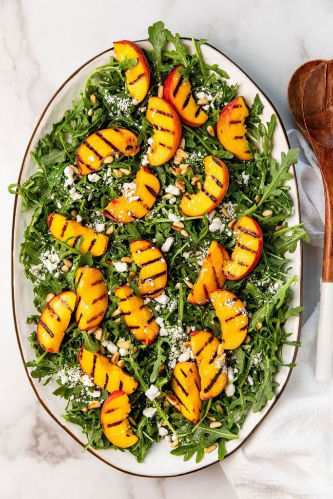 healthy grilled peach salad on a large serving platter