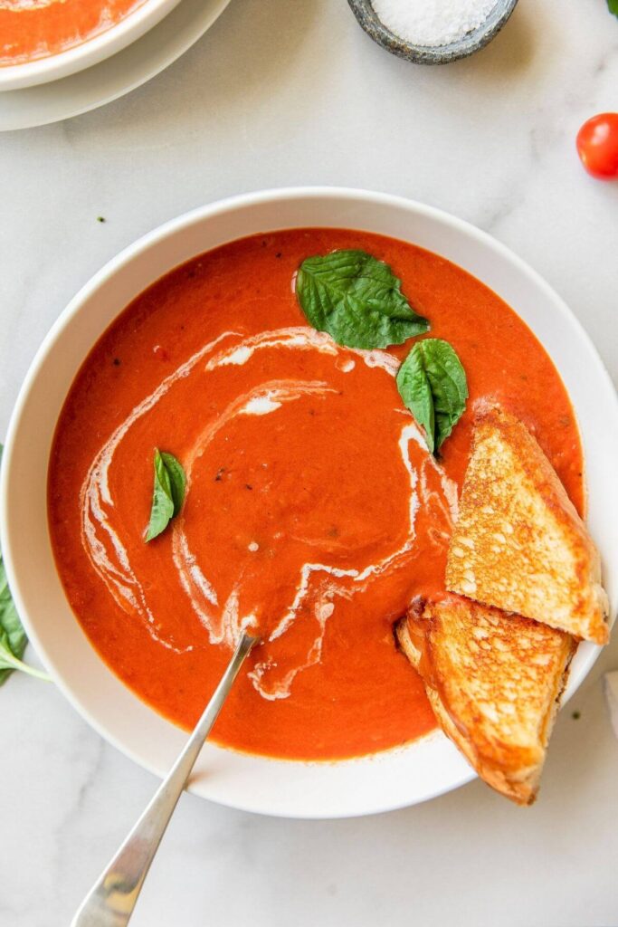 creamy healthy tomato soup with grilled cheese in it