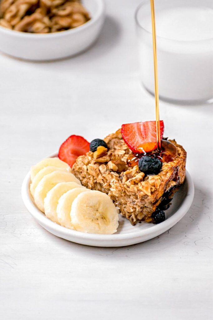 square of vegan baked oats with maple syrup pouring on top