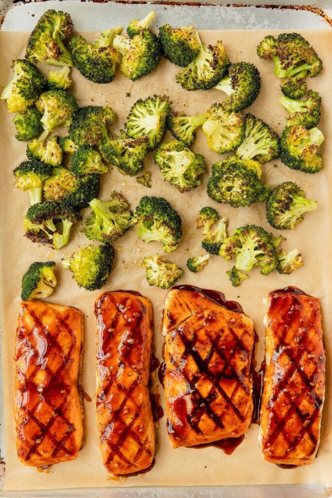 cooking teriyaki salmon and roasted broccoli on a sheet pan