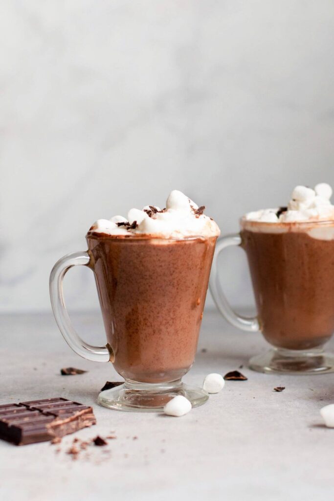 two mugs of oat milk hot chocolate with mini marshmallows on top