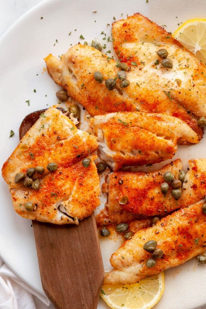 flakey air fryer tilapia with butter caper sauce on top