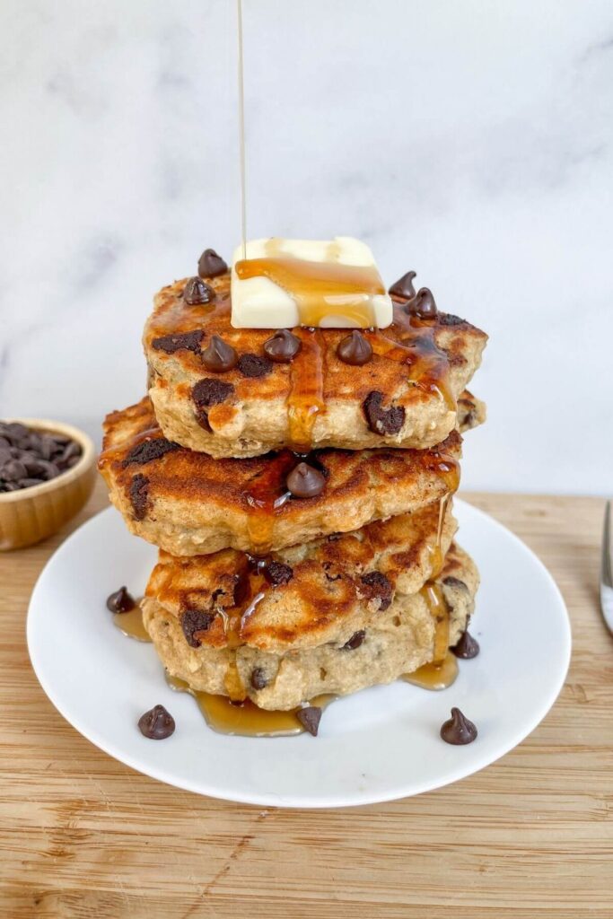 maple syrup pouring on oat flour protein pancakes