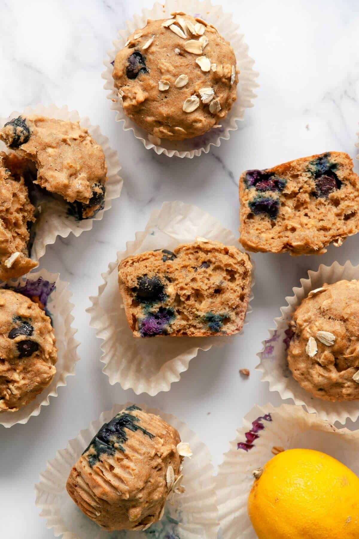 Healthy banana blueberry oatmeal muffins cut in half showing a moist fluffy center with juicy blueberries and oat flour texture.