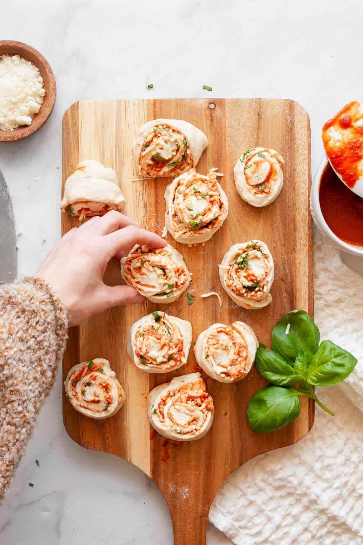 Cutting rolled pizza dough into 1-inch slices and pinching the bottoms to seal homemade air fryer pizza rolls.