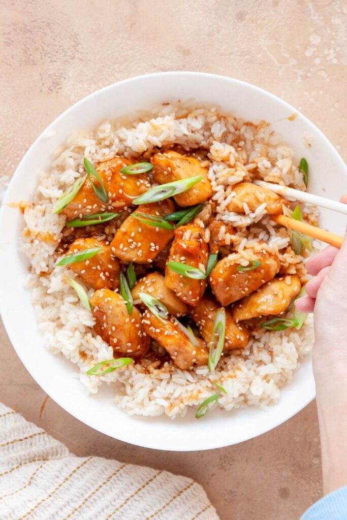 air fryer teriyaki chicken in a bowl with rice and chopsticks