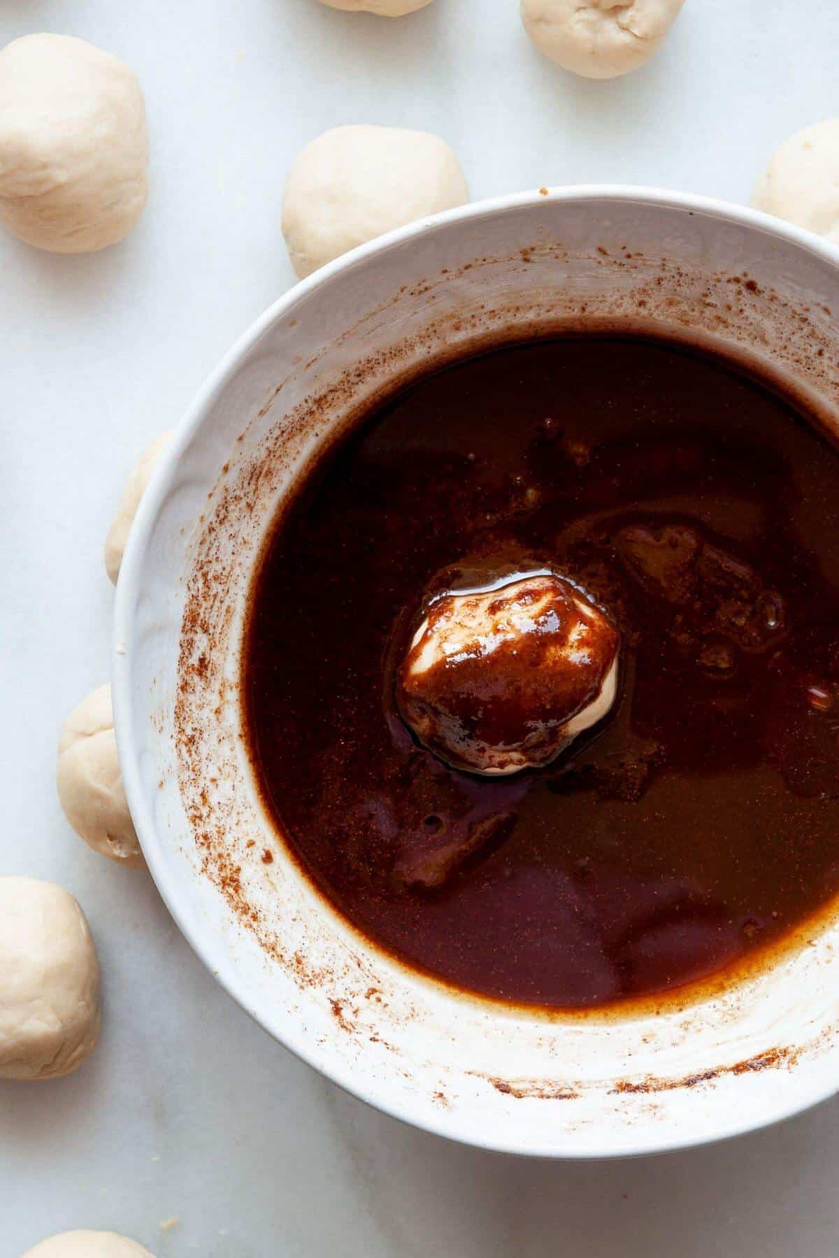 A dough ball dipped in cinnamon coconut sugar sauce.