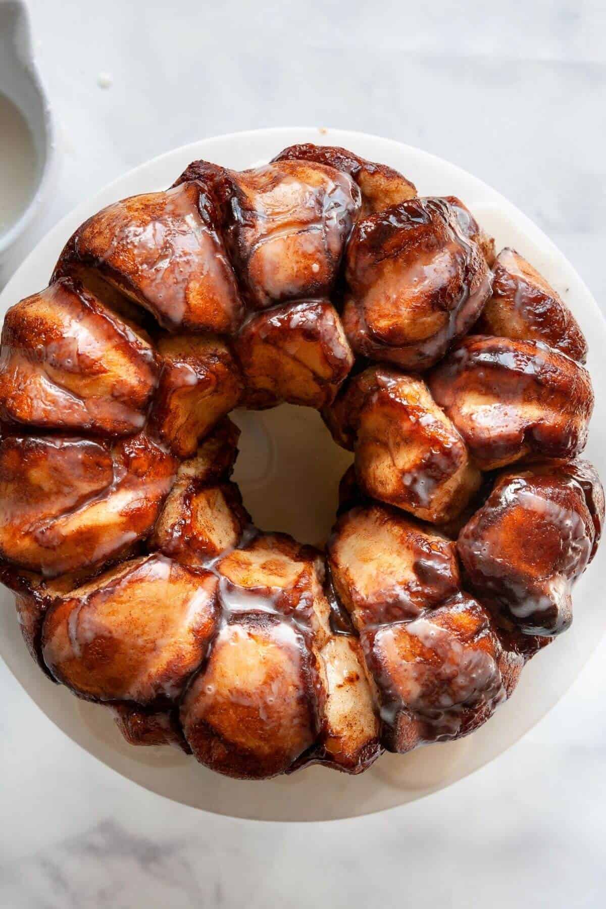 Baked vegan monkey bread in a white bundt pan, golden and glazed.