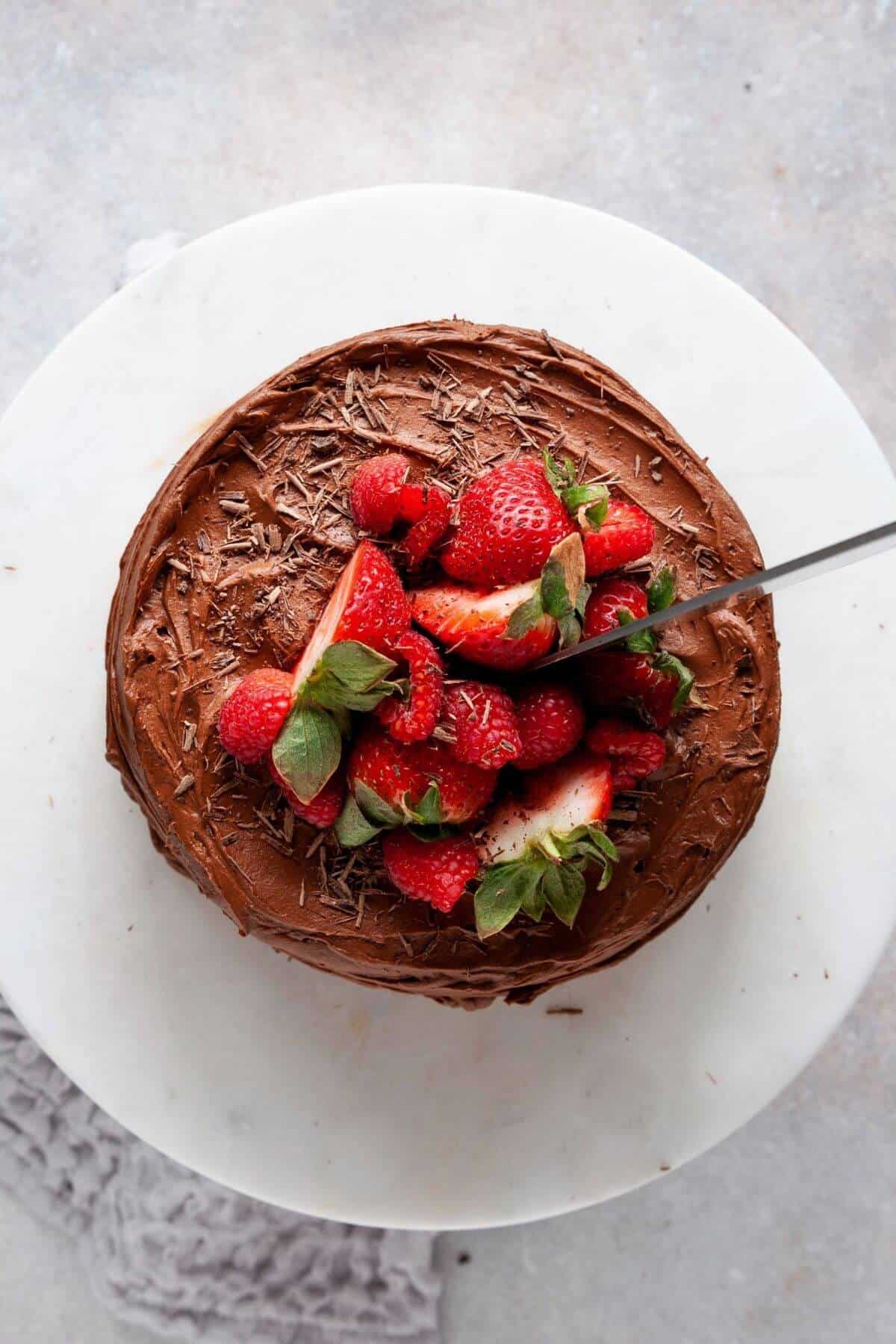 Finished almond flour chocolate cake topped with real chocolate buttercream and fresh strawberries.