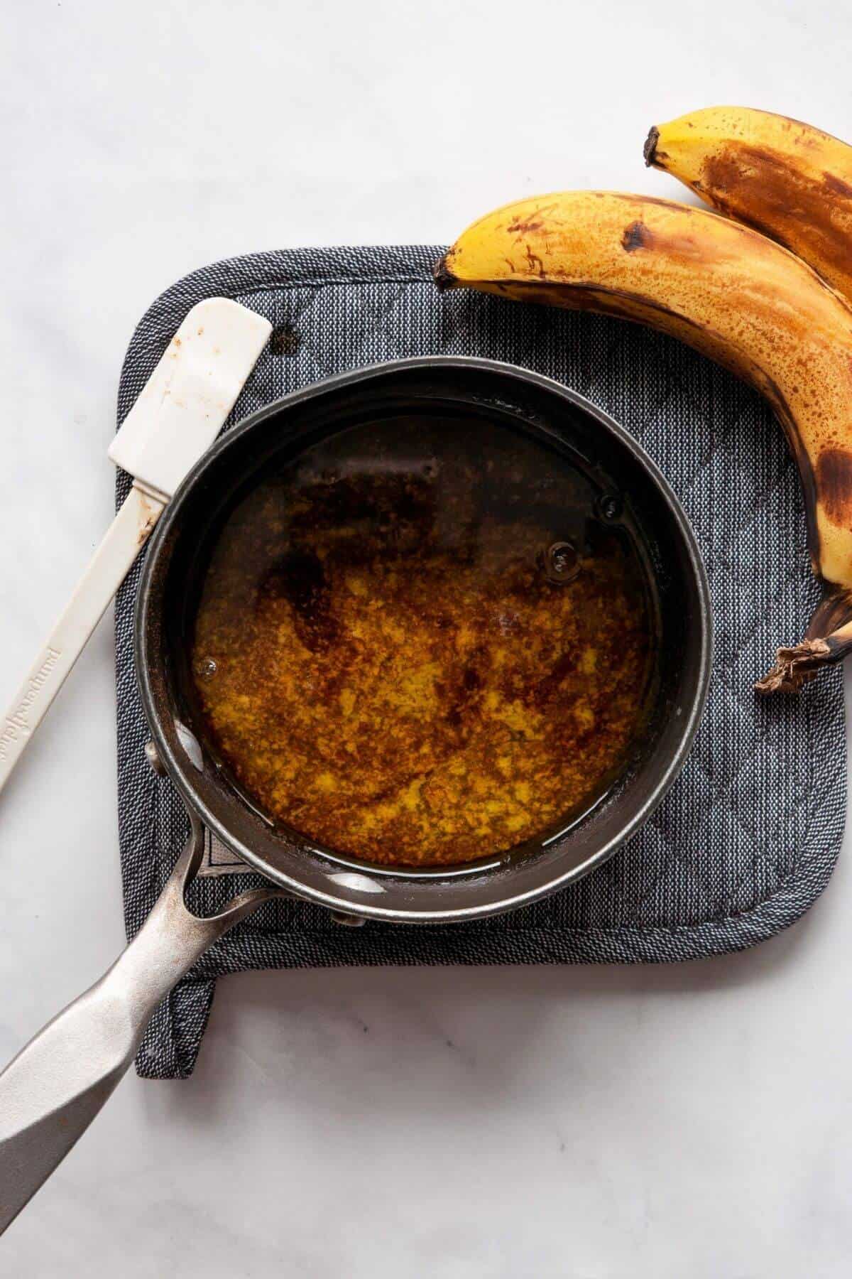 Homemade banana foster sauce simmering with butter, maple syrup, and cinnamon, no rum.