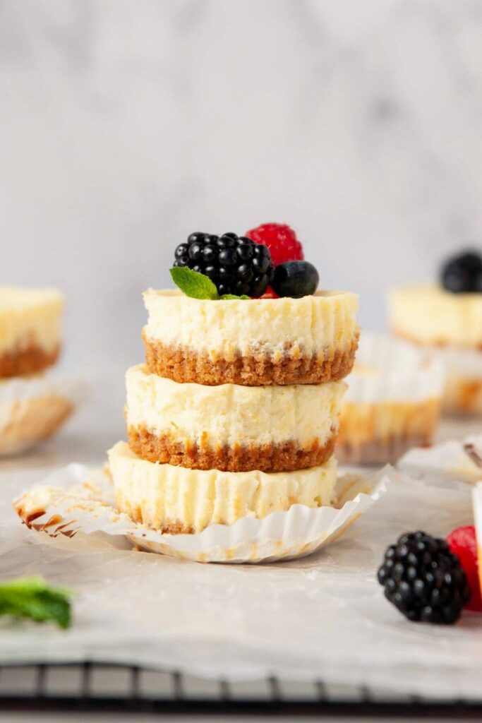 stack of three mini protein cheesecakes with fresh berries on tip
