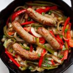 air fryer chicken sausages in pan with vegetables