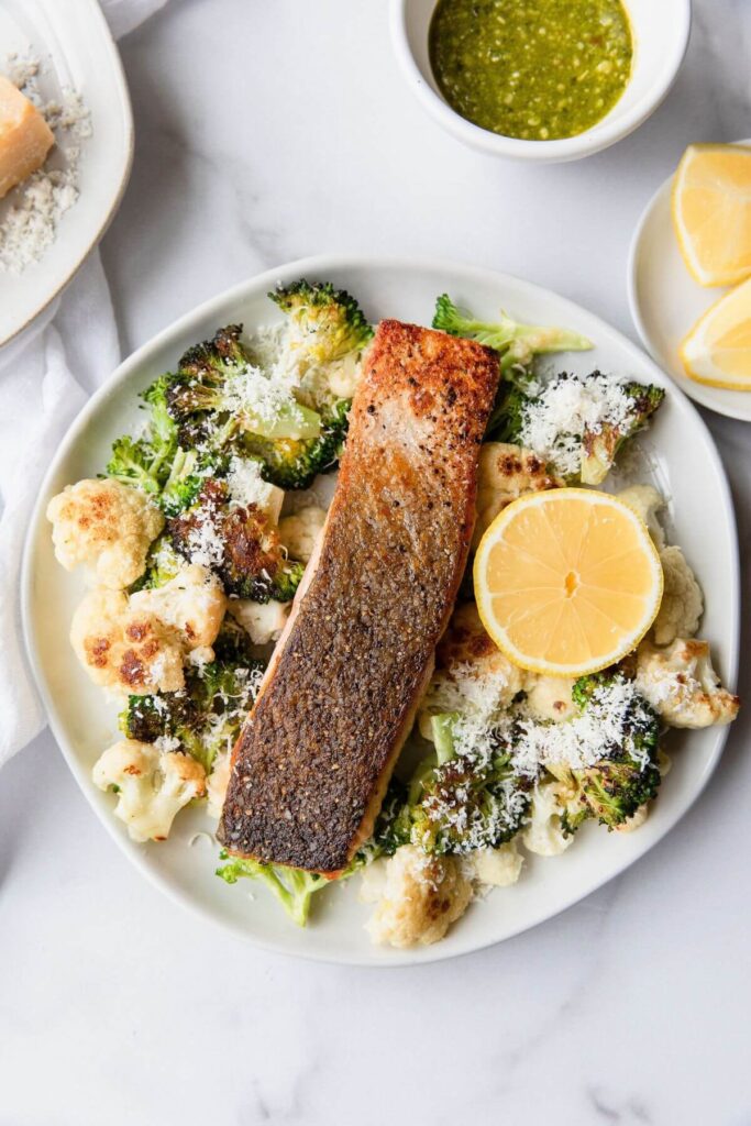 Crispy salmon on a plate with with parmesan roasted vegetables
