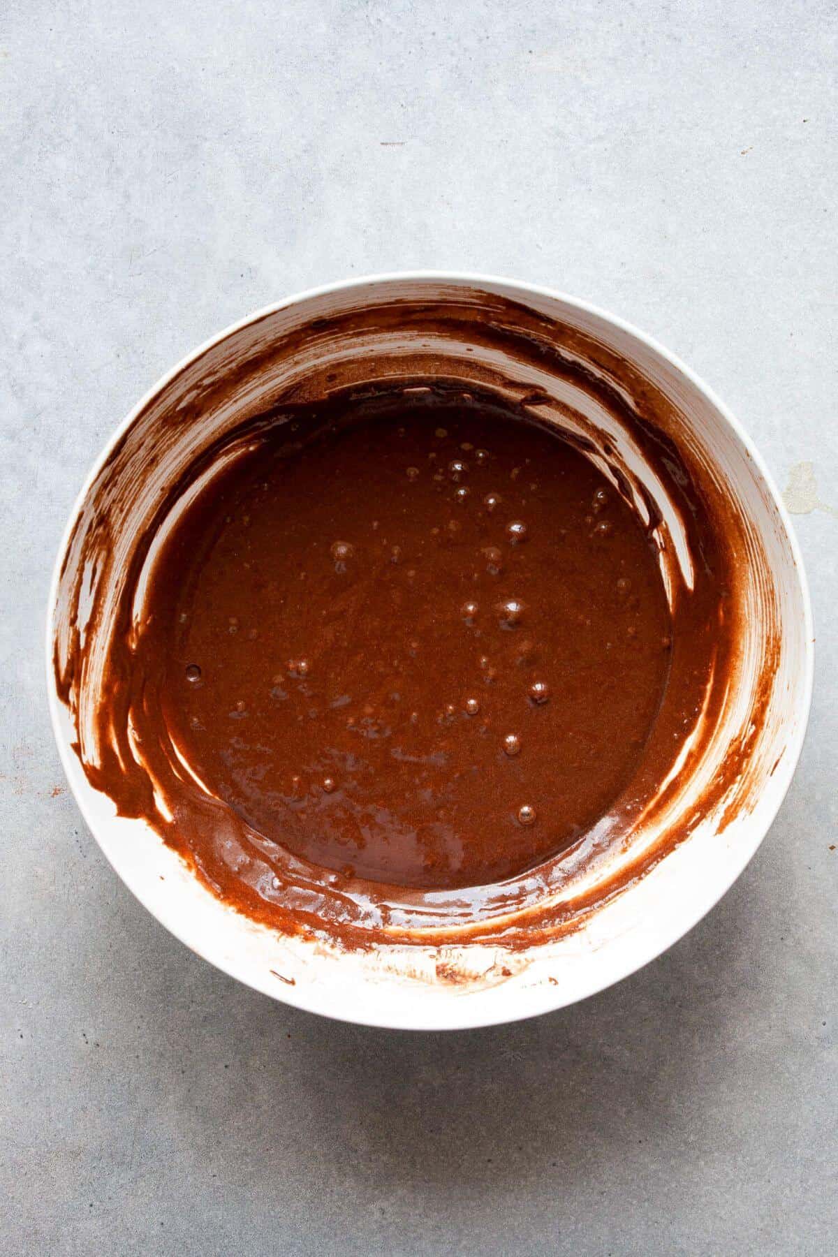 Smooth chocolate cupcake batter made with gluten-free flour and cocoa powder in a bowl.
