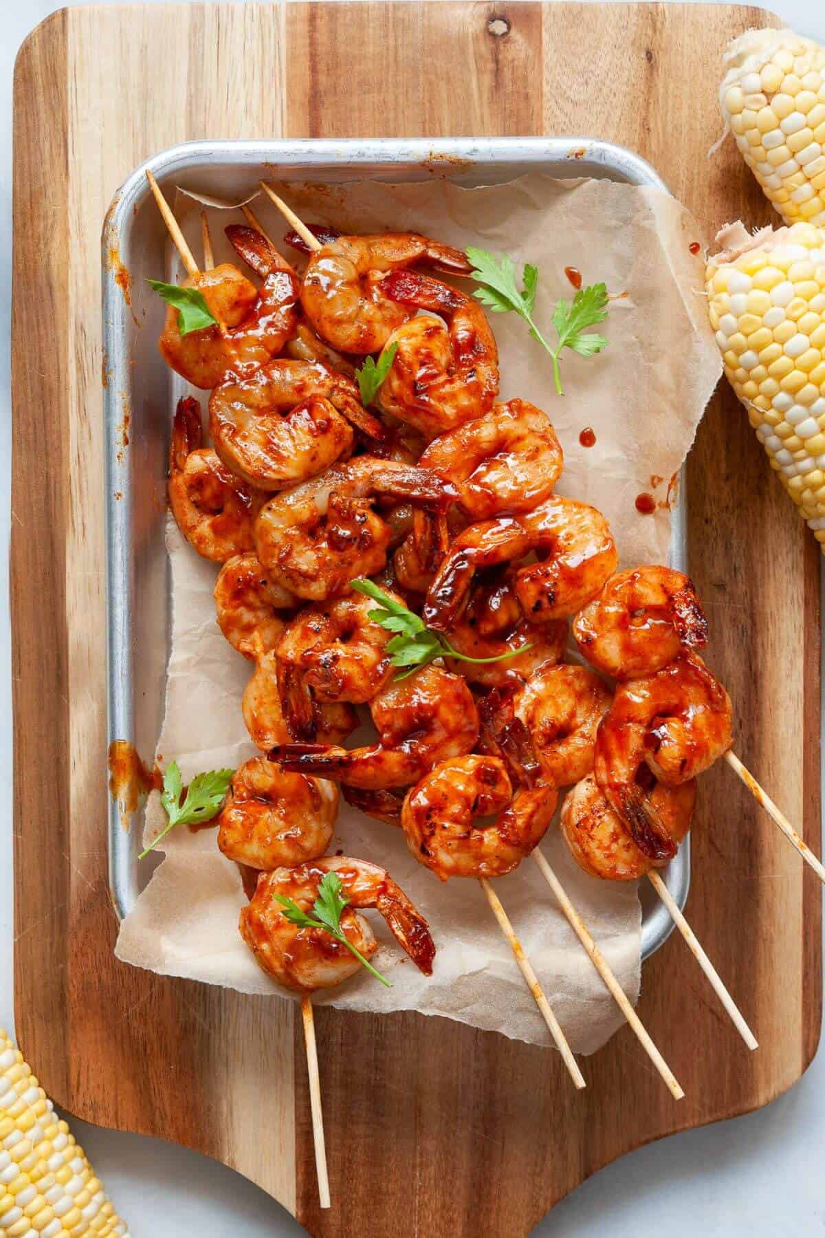 Grilled BBQ shrimp skewers garnished with parsley.
