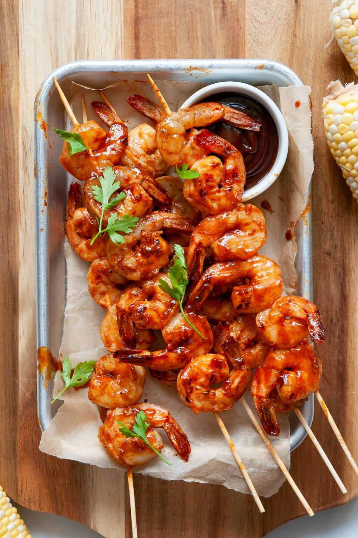 Close up of juicy grilled BBQ shrimp skewers coated in barbecue sauce.
