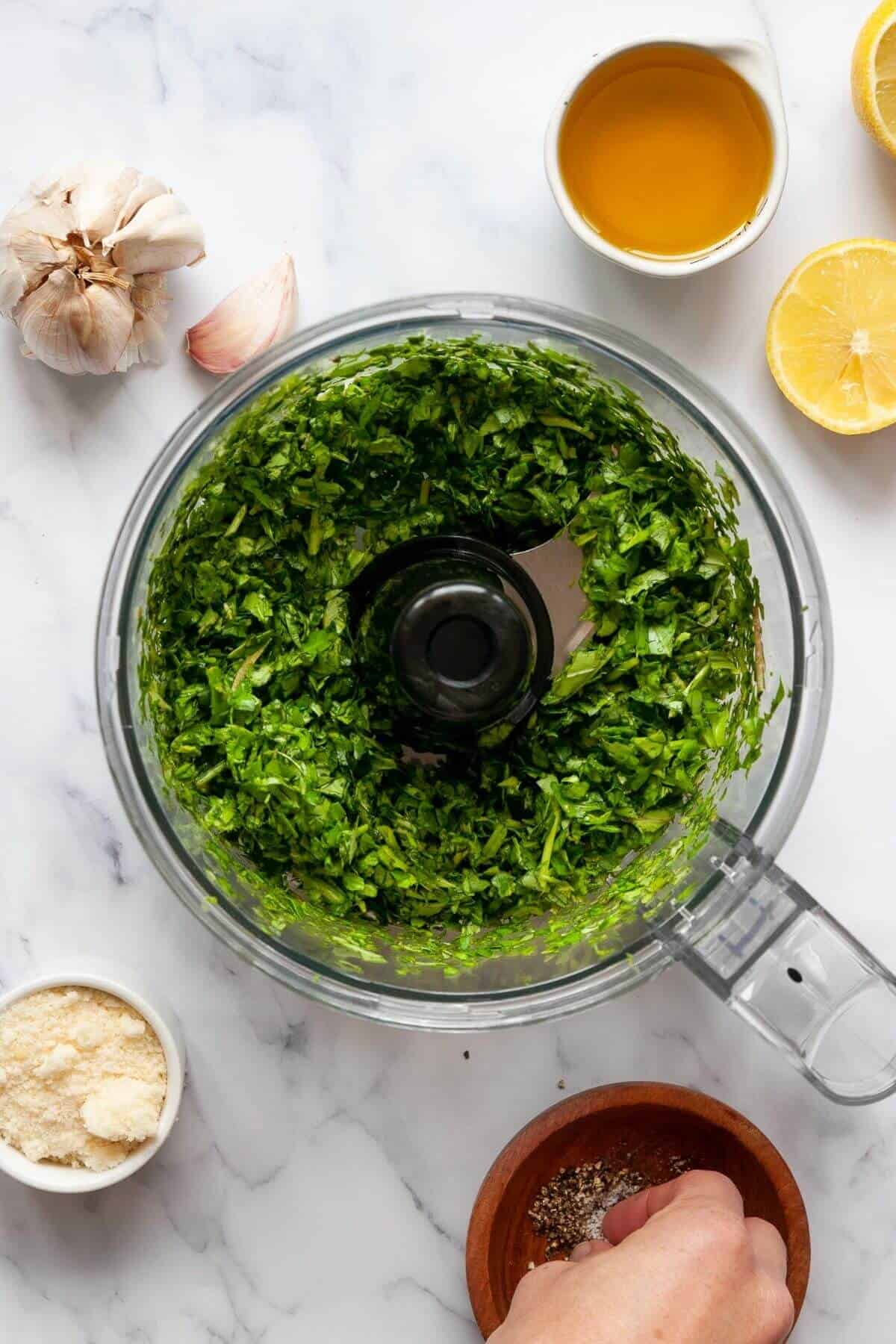 Fresh basil and baby spinach added to a food processor for nut-free pesto.