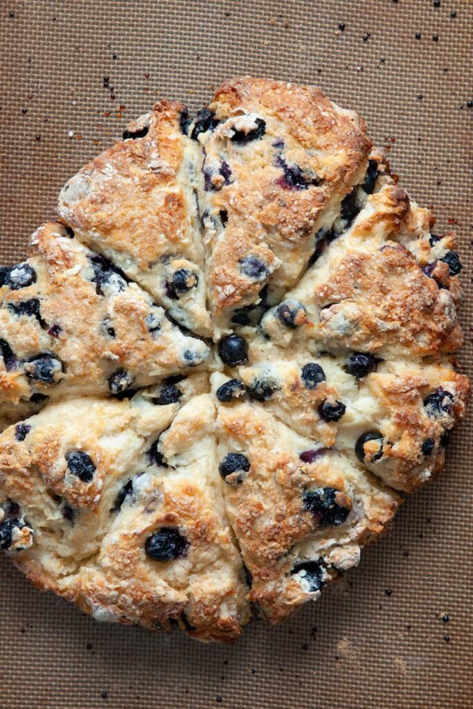 golden blueberry scones with buttery edges on a baking tray after baking in the oven