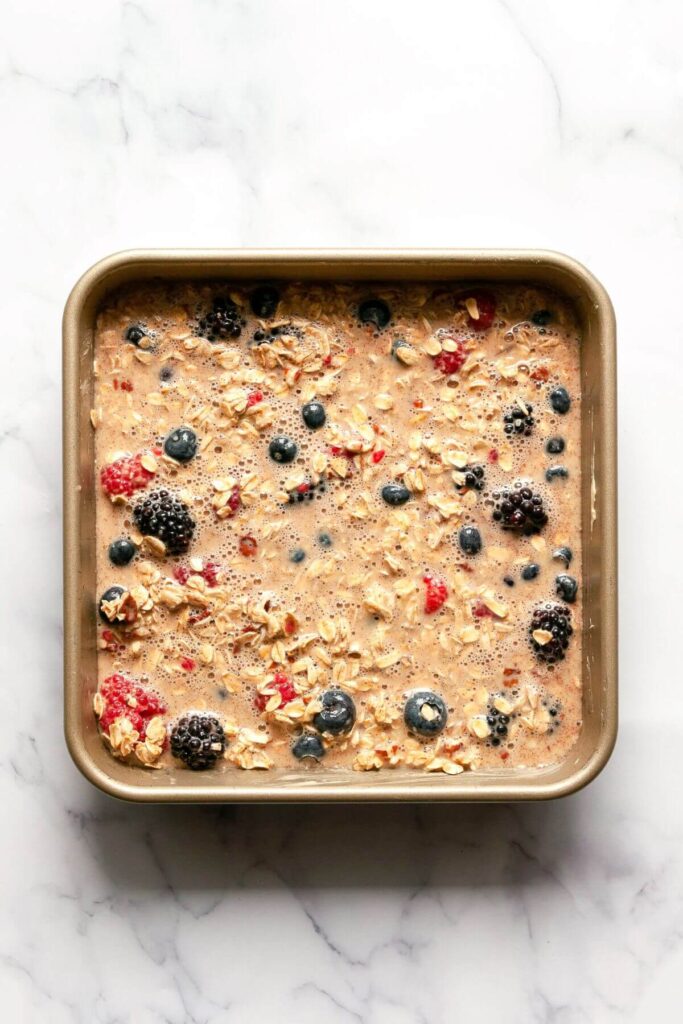 baked oats with berries mixture in baking dish before baking in the oven