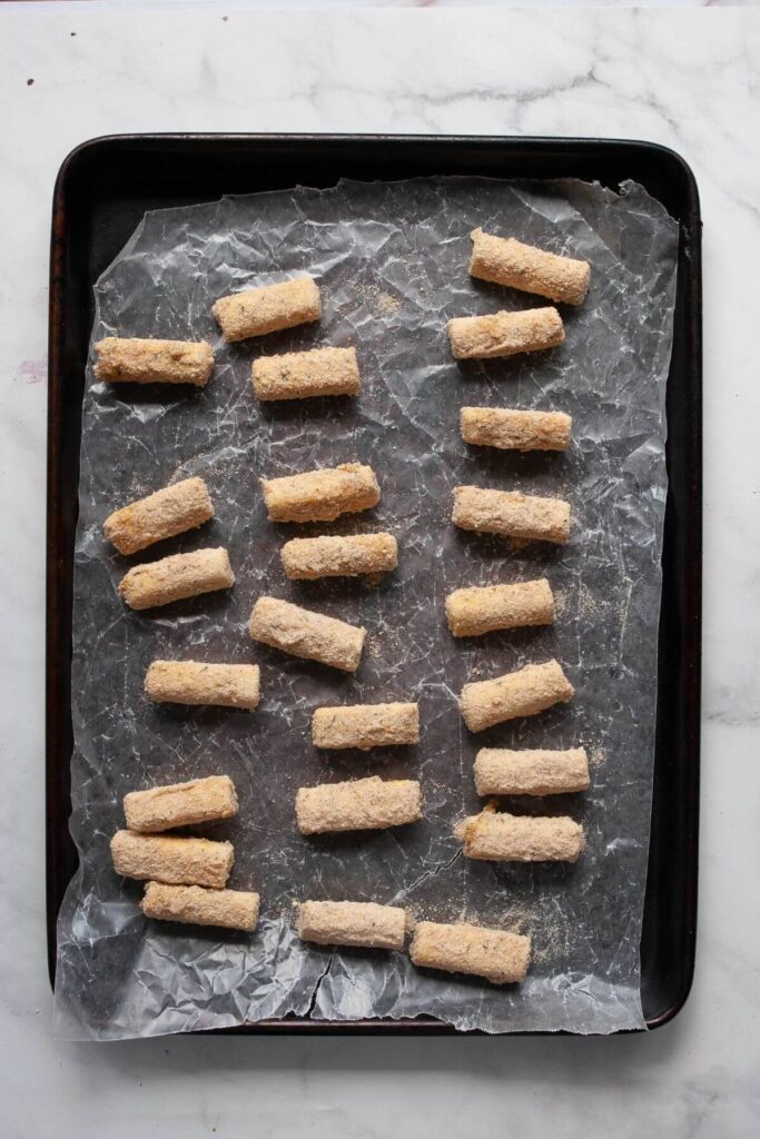 frozen mozzarella sticks on a baking tray before baking