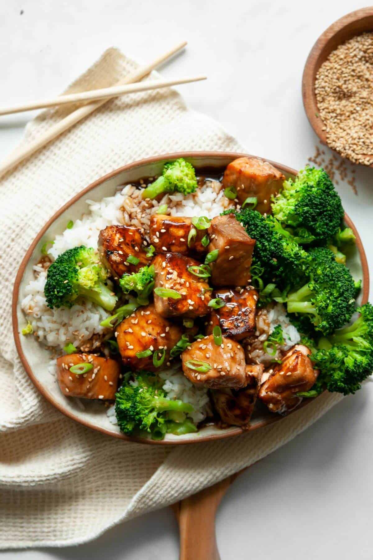 Air fryer teriyaki salmon bites in a bowl with rice and broccoli.