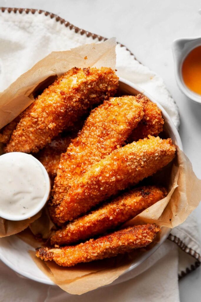 hot honey chicken tenders in a bowl with ranch