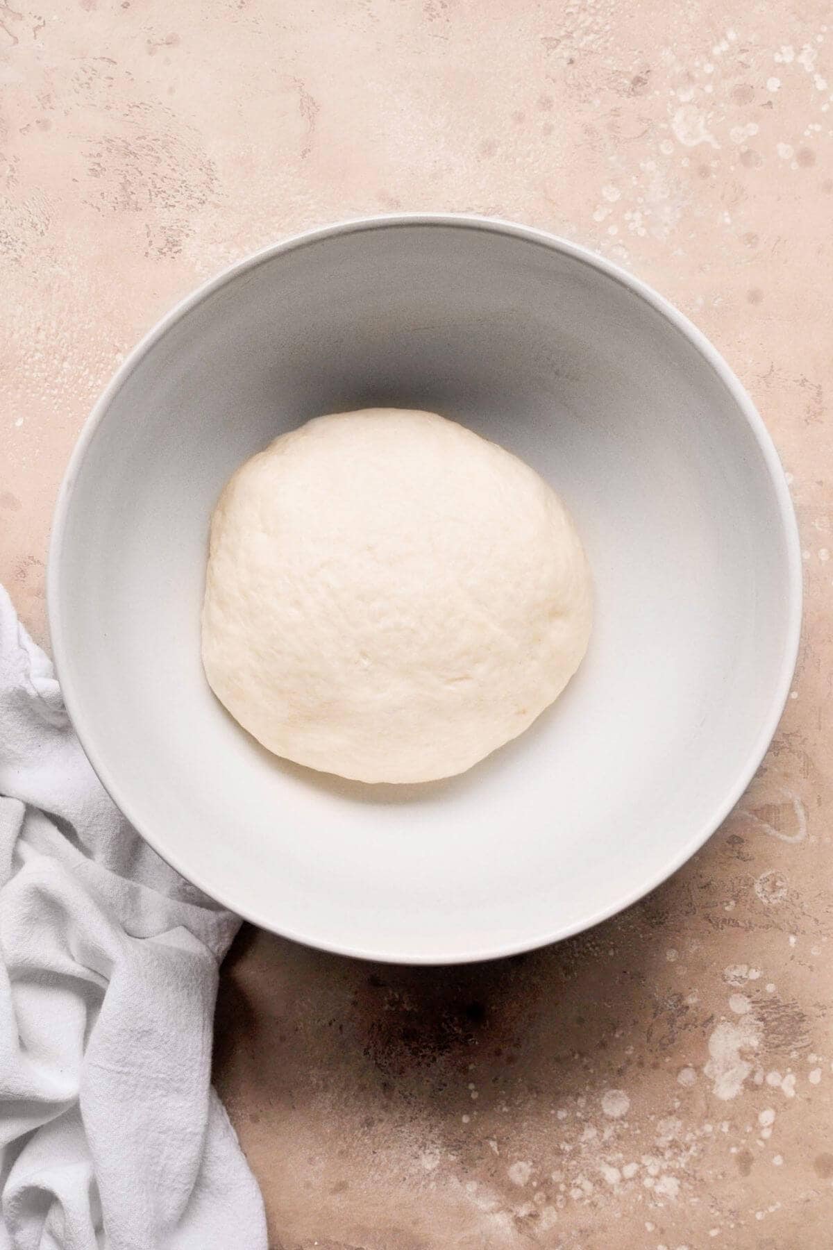 Proofed cinnamon roll dough doubled in size in a bowl.