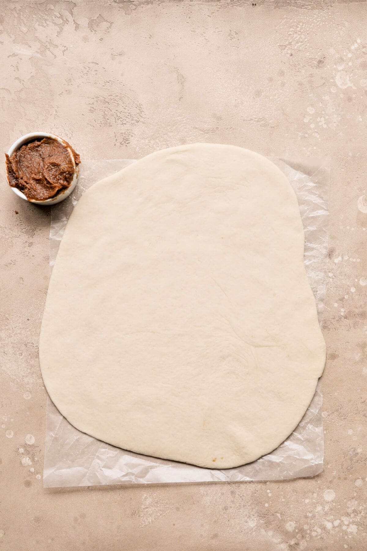 Cinnamon roll dough rolled into a rectangle.