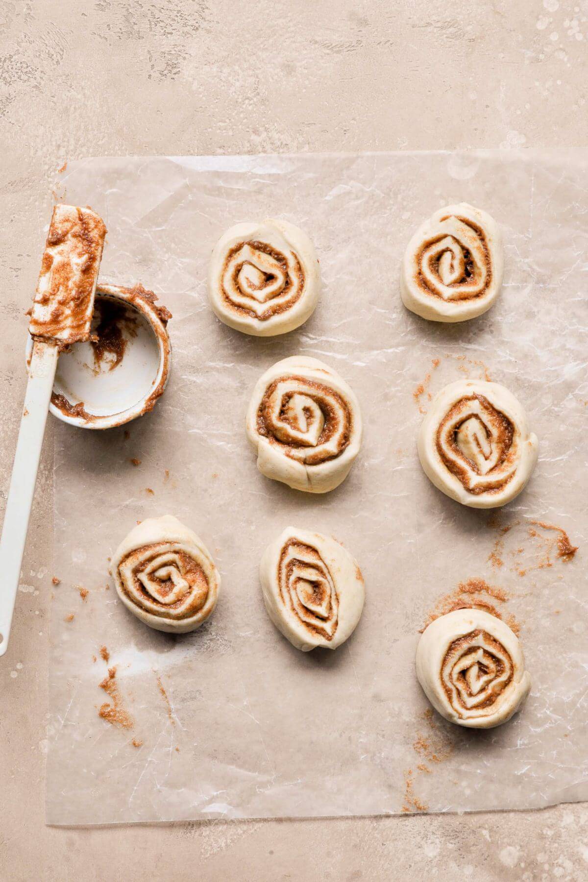 Cinnamon roll dough log cut into eight rolls.