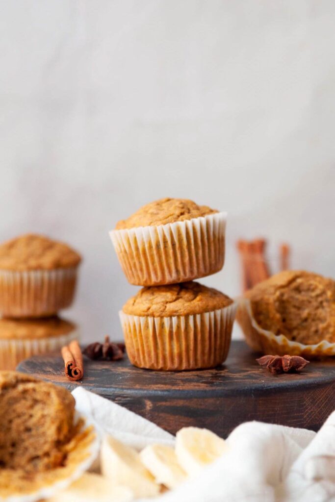 two banana pumpkin muffins stacked on top of each other