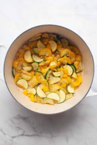 sautingn yellow squash, zucchini, and yellow bell pepper in a dutch oven