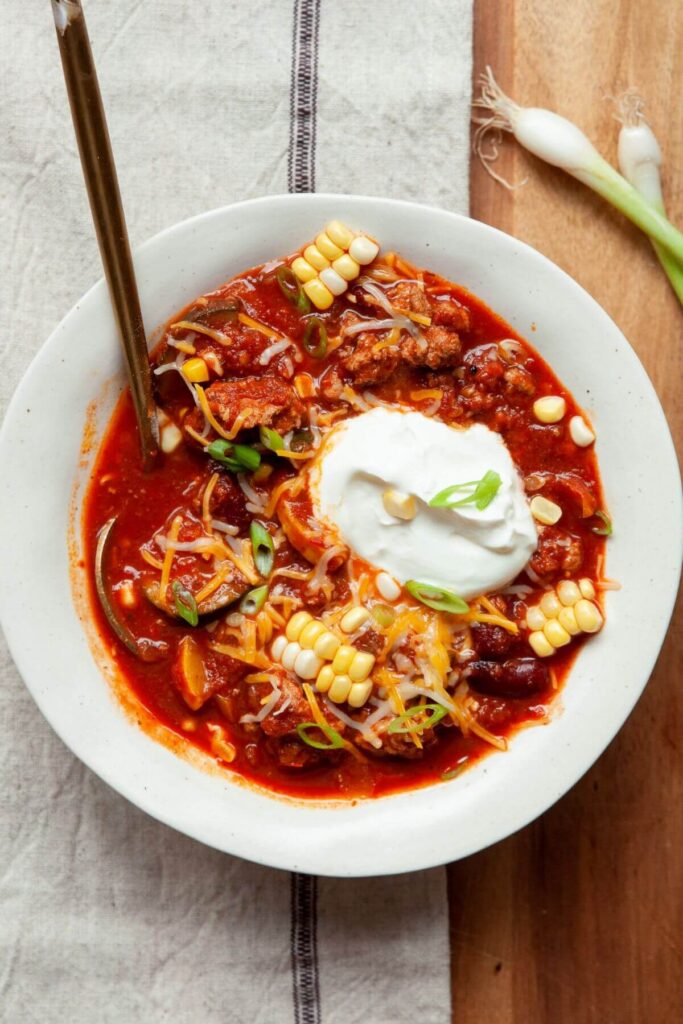 healthy chili recipe in a serving bowl with corn and greek yogurt on top