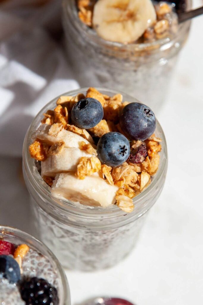 oat milk chia pudding with granola, banana slices, and blueberries on top