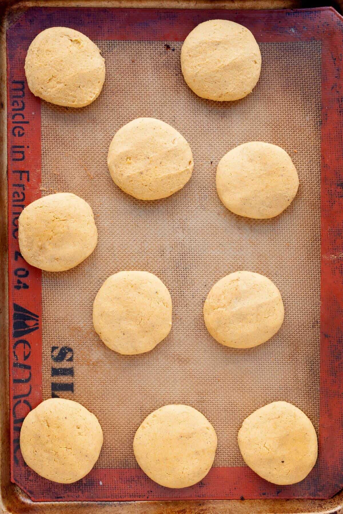 Freshly baked gluten-free pumpkin cookies on a tray, soft, pillowy, and lightly golden on the bottoms.