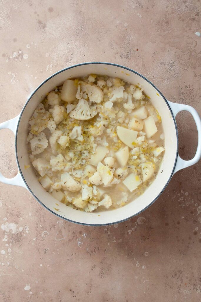 cauliflower florets and potato cubes cooking in vegetable broth in one pot