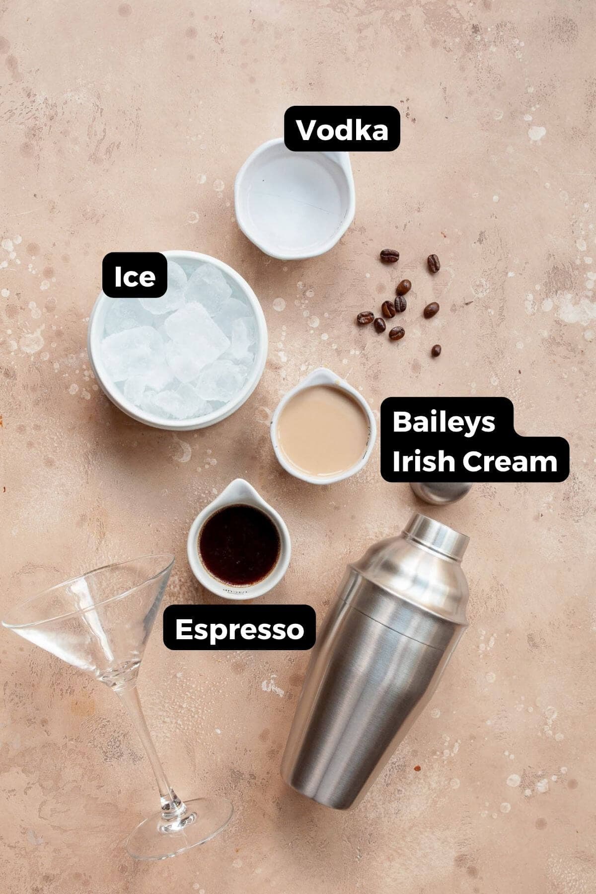 All ingredients in this espresso martini labeled in small bowls, including: Espresso, Vodka, and Baileys Irish Cream.