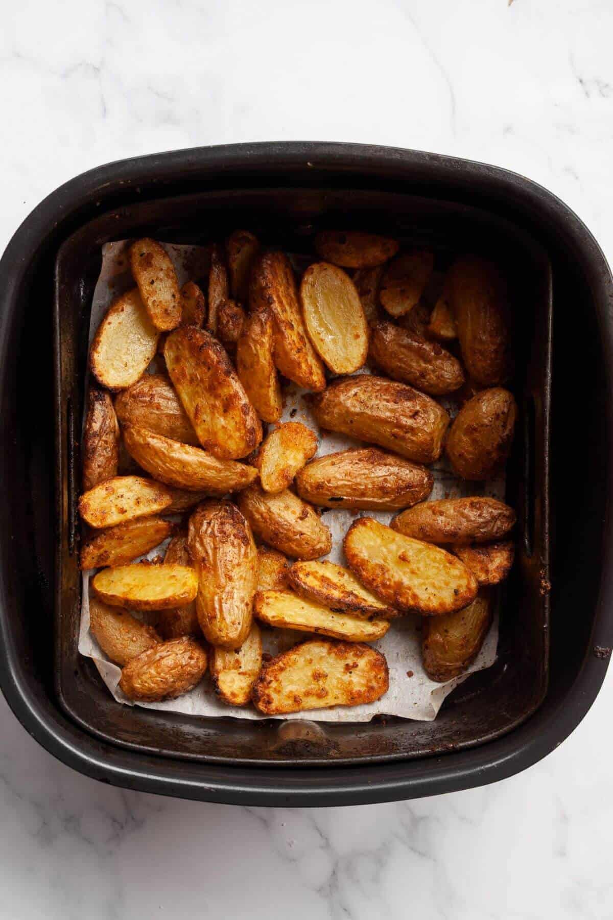 Crispy fingerling potatoes after being cooked in an air fryer basket.
