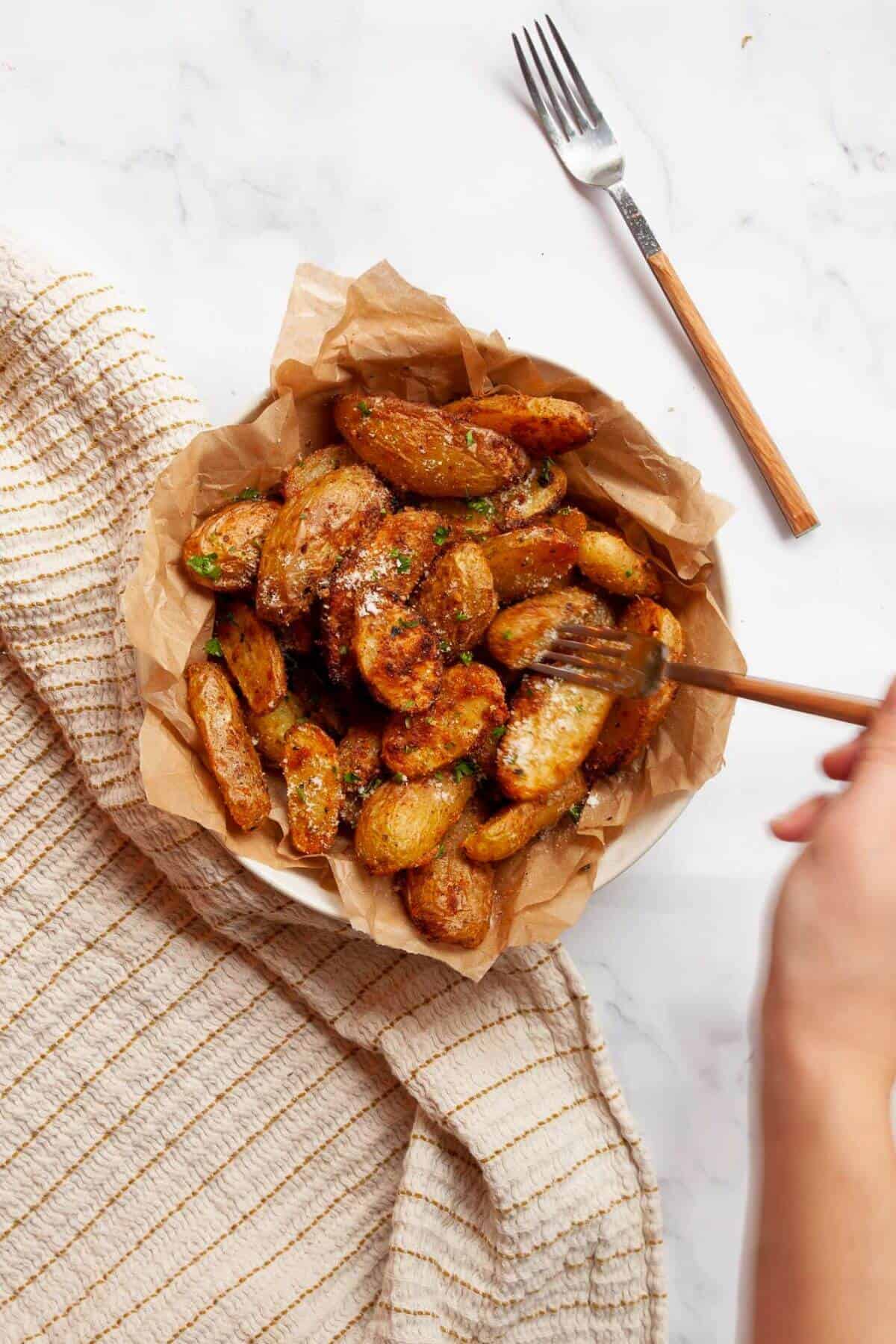 Crispy parmesan garlic air fryer fingerling potatoes in a serving bowl.