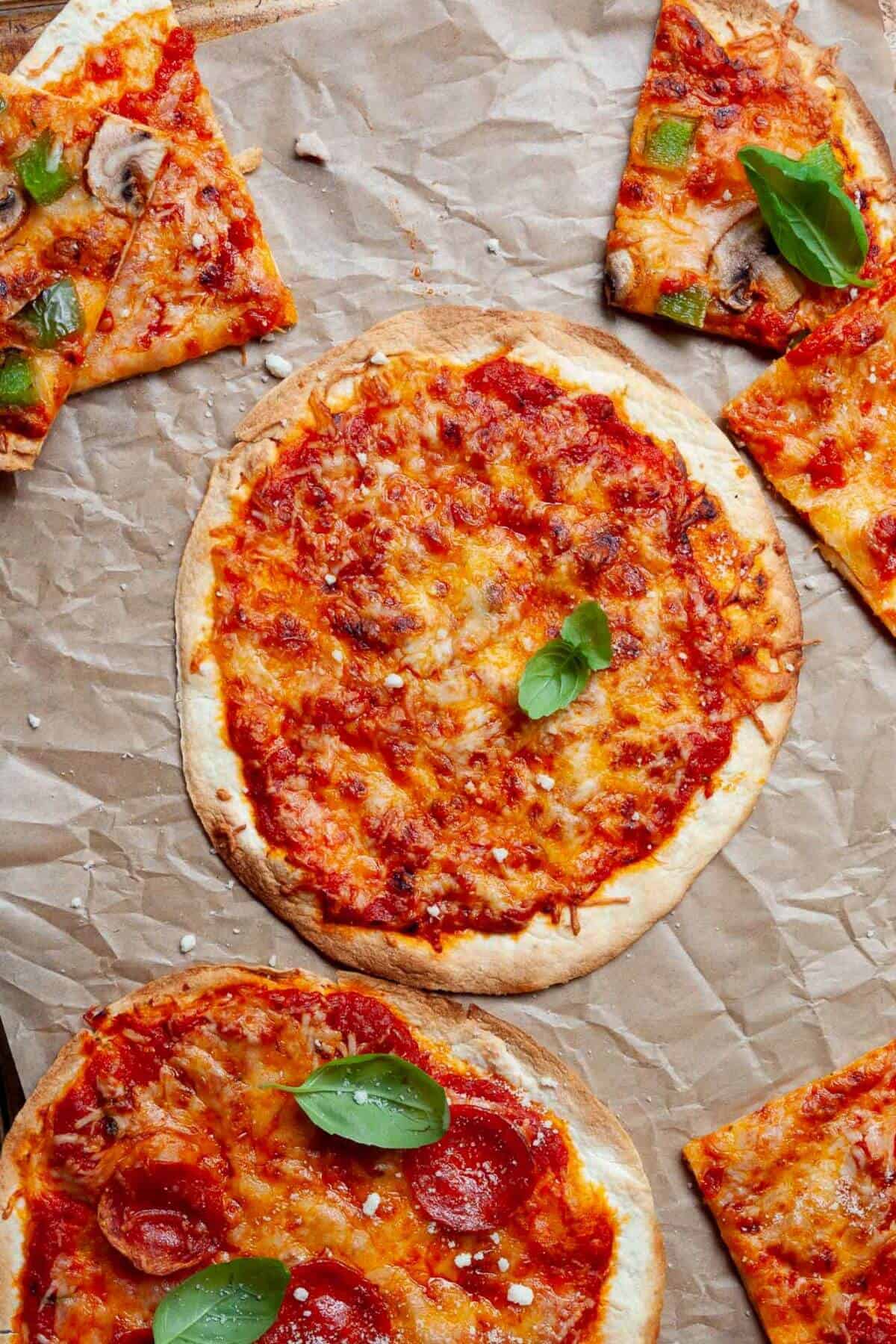 Single-serve crispy air fryer tortilla pizza with melted cheese and crispy crust on parchment paper.