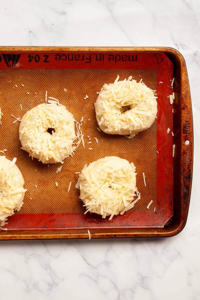 unbaked asiago bagels on a baking sheet
