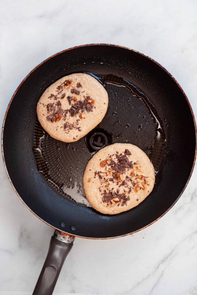 cooking chocolate chip walnut banana pancakes in pan