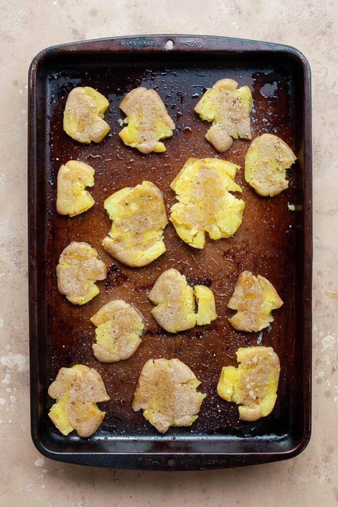 uncooked smashed fingerling potatoes on a baking sheet before roasting in oven