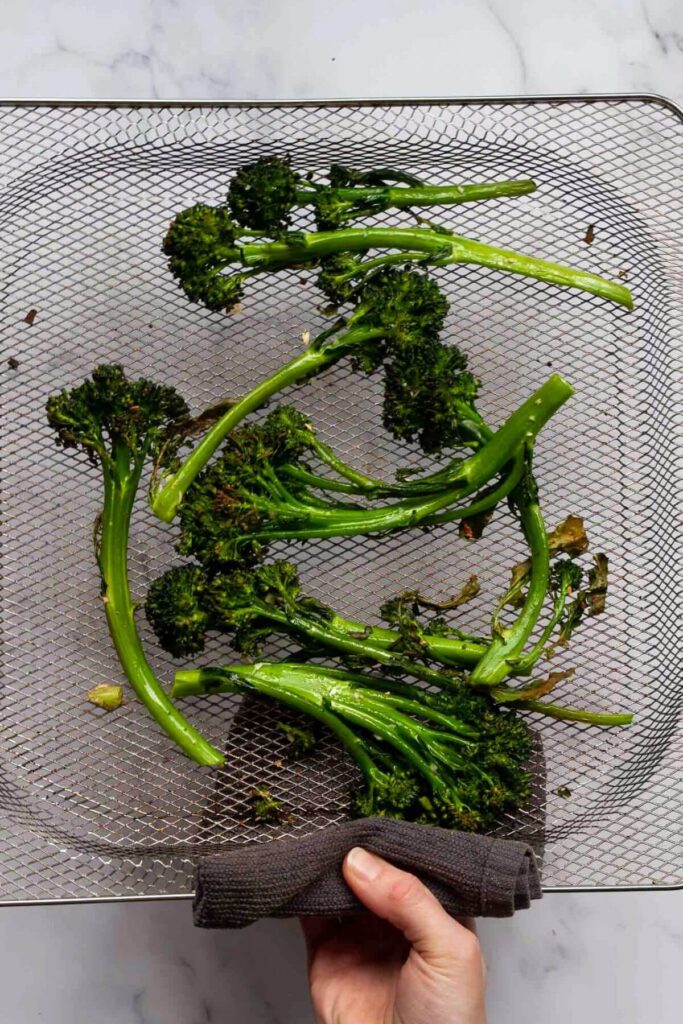 crispy broccolini in air fryer basket after roasting