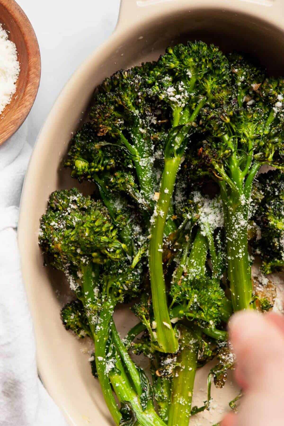 Garlic lemon air fryer broccolini in a bowl with crispy edges and tender stalks.