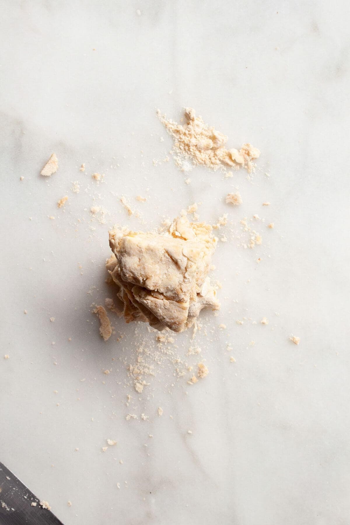Shaggy biscuit dough coming together in a mixing bowl.