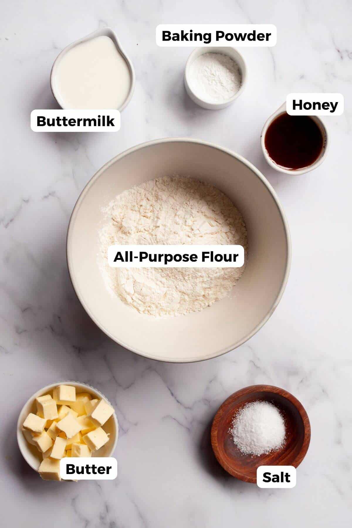 Measured ingredients for air fryer biscuits including flour, butter, buttermilk, honey, baking powder, and salt.